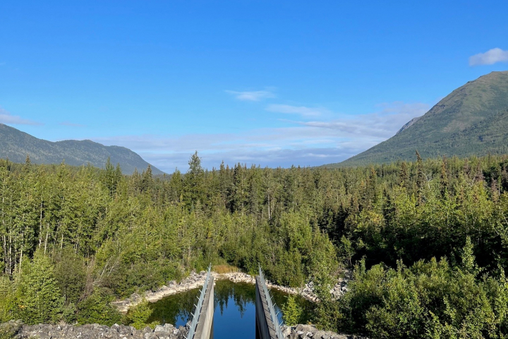 Eklutna dam on a sunny day. Mountains and blue sky in the background.